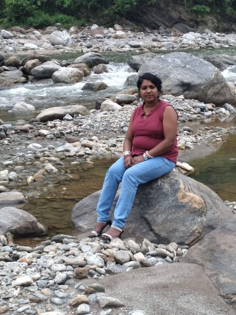 a person sitting on a rock in a river